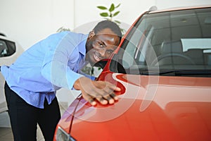 New Car Owner. Happy African American Man Touching Hugging His Brand-New Auto