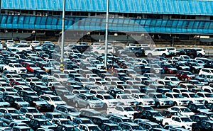 New car parked in a row at parking lot of factory. Car dealer inventory stock. Automotive industry. Car dealership concept.