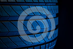 New car tire. Road wheel on dark background. Summer Tire with asymmetric tread design