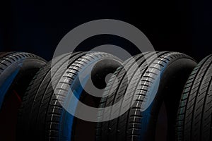 New car tires. Group of road wheels on dark background. Summer Tires with asymmetric tread design