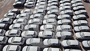 New cars covered in protective white sheets parked in a holding platform.