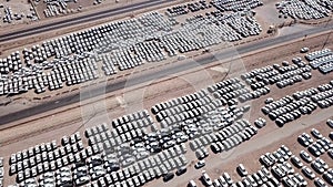 New cars covered in protective white sheets parked in a holding platform.