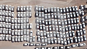 New cars covered in protective white sheets parked in a holding platform.