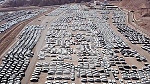 New cars covered in protective white sheets parked in a holding platform.