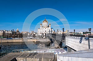 The new Cathedral of Christ the Saviour and the Patriarchy pedestrian bridge over the Moscow River in Moscow. Russia.