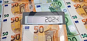 New challenges in 2024. Calculator on the background of 50 and 100 euro banknotes. Inflation, economic crisis, elections