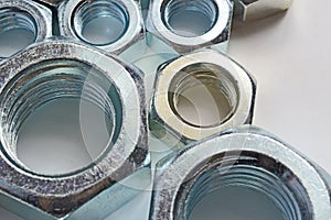 New chrome screw-nut of different sizes on a white background. Concept