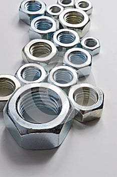 New chrome screw-nut of different sizes on a white background. Concept