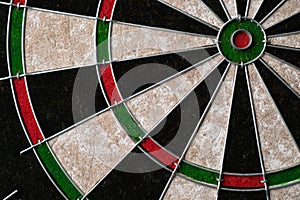 New classic professional sisal dart board on black wooden background. Close up.