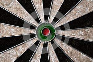 New classic professional sisal dart board on black wooden background. Close up.