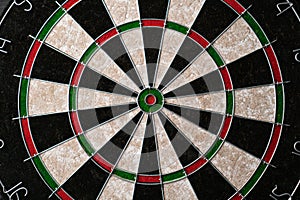 New classic professional sisal dart board on black wooden background. Close up.