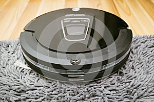 New Clean Robot vacuum cleaner on laminate wood floor.