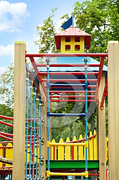 New colorful castle playhouse with climbing frame and rope ladder on children`s playground