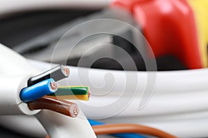 New colorful electrical wire on blurred background, closeup. Space for text