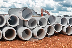 New concrete pipes stacked on a construction site. Preparation for the manufacture of the sewer system