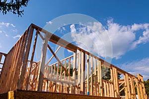 New construction home framing against a blue sky