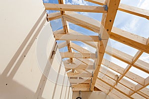 New construction home framing against blue sky, closeup of ceiling frame.with plasterboard wall