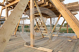 New construction home framing against blue sky at sunset