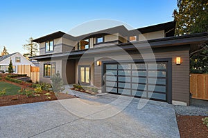 New construction home with low slope roof and brown siding.