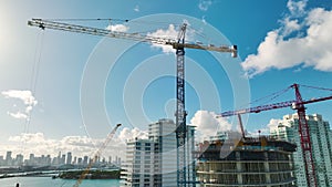 New construction site of developing residense in american urban area. Industrial tower lifting cranes in Miami, Florida