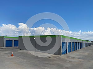 new construction storage rental building business stalls shed garage doors blue gray paved driveway industrial building