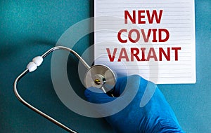 New covid variant symbol. Hand in blue glove with white card. Concept words `New covid variant`. Stethoscope. Medical and COVID- photo