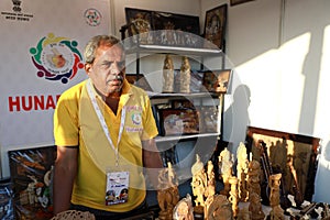 New Delhi, India - February 15, 2020 - A Seller selling wooden idols at the Hunar Haat. An exhibition of Artisans / Craftsmen and