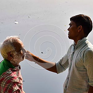 New Delhi, India - March 04, 2020: Handsome old man shaving his beard in bathroom during morning time at Yamuna river ghat in New