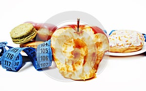 new diet concept, question sign in shape of measurment tape between red apple and donut isolated on white