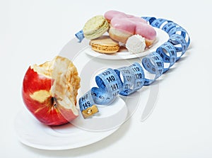 New diet concept, question sign in shape of measurment tape between red apple and donut isolated on white