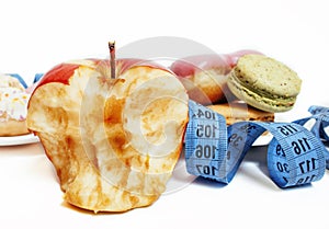 New diet concept, question sign in shape of measurment tape between red apple and donut isolated on white