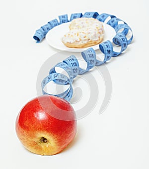 New diet concept, question sign in shape of measurment tape between red apple and donut on white