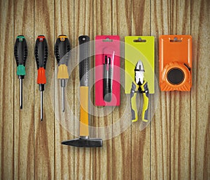 New different construction tools are hanging on a wooden wall photo