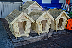 New dog booths made of wood on the street near the wall