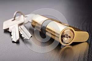 A new door lock on a dark background. A patent and keys to secure the front door