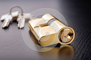 A new door lock on a dark background. A patent and keys to secure the front door