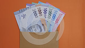 New edition of Indonesian banknotes in a brown envelope for THR (tunjangan hari raya) and salary