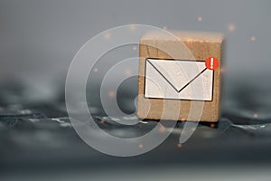 New email graphic symbol on wooden block over black computer keyboard