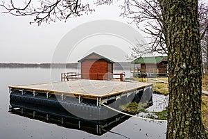 A new empty wooden platform on pontoons in the lake for the creation of a holiday house on the water