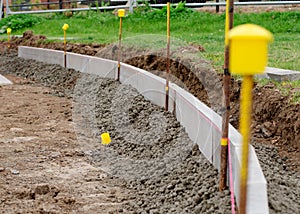 New footpath construction, placing edging kerb on semi-dry concrete along string line to future/designed finish road/footpath