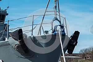 New front of forecastle deck forward ship military ship gray color with rope, anchor alongside in port on sky blue