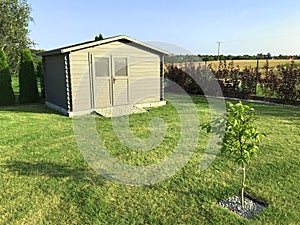 New garden house or shed in green lawn or grass