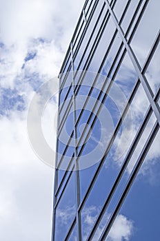 New glass building with reflecting clouds