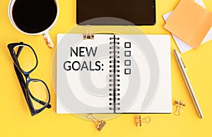 NEW GOALS  plan  action text on notepad with office accessories. Business motivation inspiration concepts