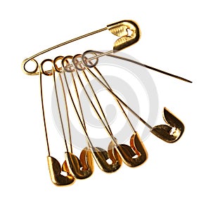 New golden safety pins on white background