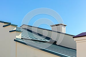New gray corrugated metal roof against blue sky background