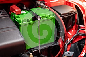 New green car battery installed near the car engine