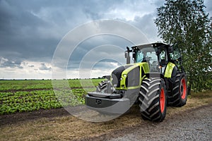 a new green tractor stands near the field, beautiful sky