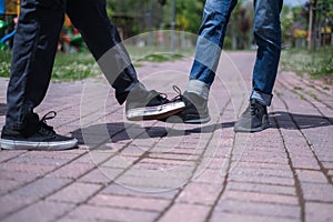 New greeting style during coronavirus epidemic..Two friends bump feet outdoors