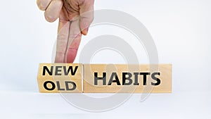 New habits symbol. Businessman turns a wooden block and changes words `old habits` to `new habits`. Beautiful white background